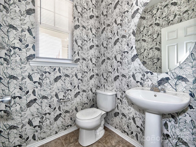 bathroom featuring toilet, tile patterned flooring, wallpapered walls, and baseboards