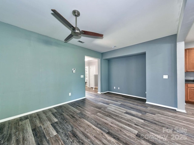 interior space with a ceiling fan, visible vents, baseboards, and dark wood-type flooring