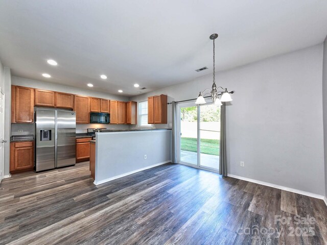 kitchen with a chandelier, stainless steel appliances, visible vents, baseboards, and dark countertops