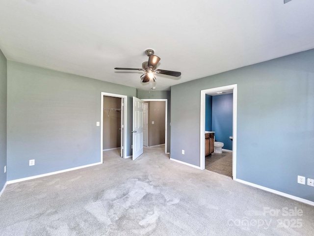 unfurnished bedroom with a spacious closet, light carpet, and baseboards