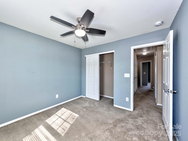 unfurnished bedroom featuring attic access, a closet, ceiling fan, carpet, and baseboards