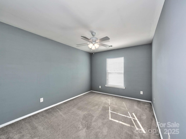 carpeted empty room featuring a ceiling fan and baseboards
