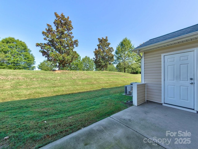 view of yard with central AC unit and a patio
