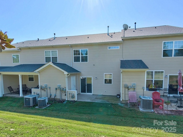 rear view of house with cooling unit, a patio area, and a yard