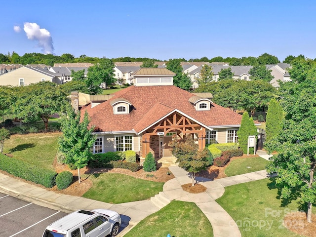 mediterranean / spanish-style house with uncovered parking, fence, a residential view, and a front yard