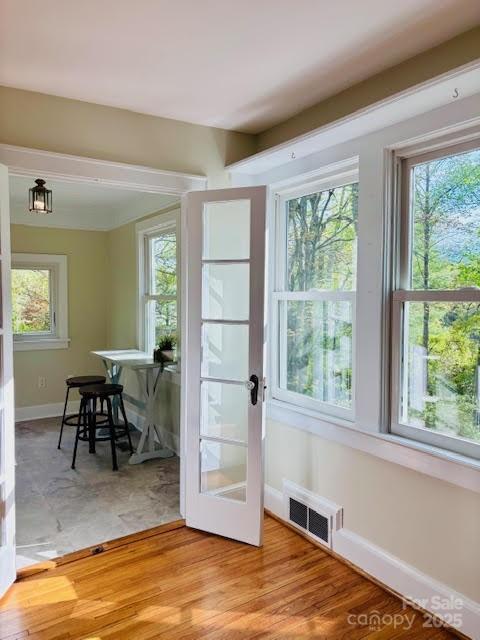 doorway featuring plenty of natural light, baseboards, light wood finished floors, and french doors