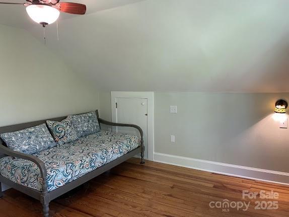 bedroom with lofted ceiling, wood finished floors, baseboards, and ceiling fan