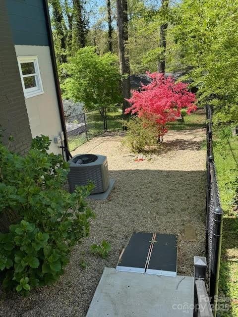 view of yard featuring central AC unit and fence