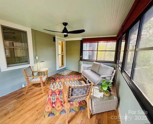 sunroom / solarium featuring ceiling fan