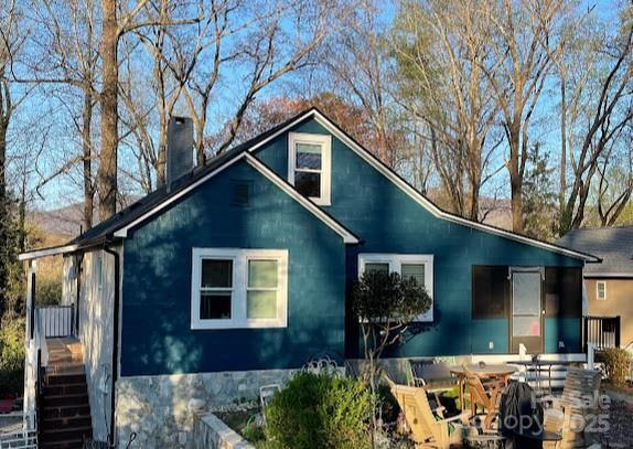 rear view of house featuring a chimney and a patio