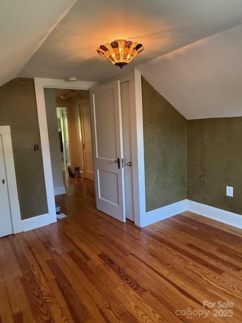 bonus room with lofted ceiling, wood finished floors, and baseboards