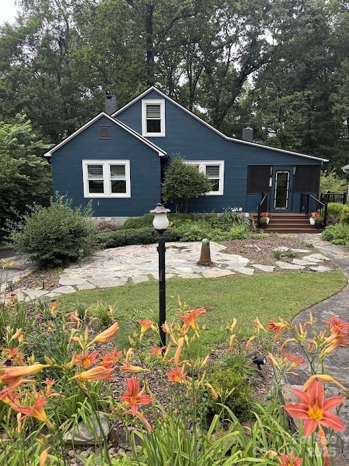 114 Broadway Ave, Tryon, NC 28782 - view of front of house featuring a chimney and a front yard