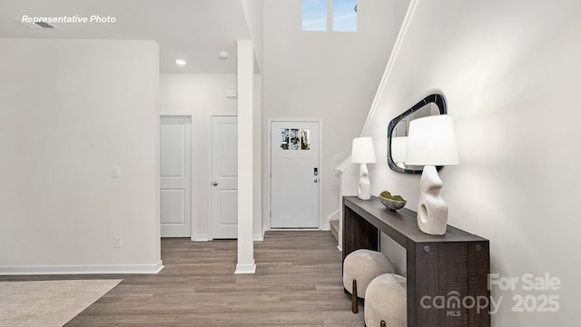 entrance foyer featuring wood finished floors, stairs, and baseboards