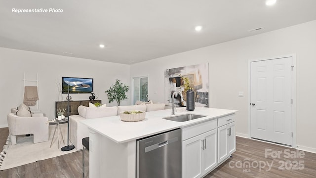 kitchen with open floor plan, wood finished floors, stainless steel dishwasher, and a sink
