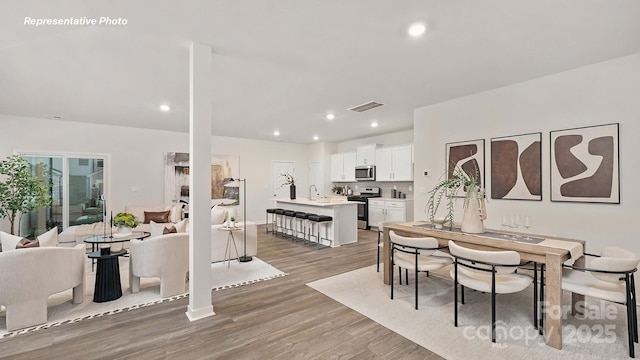 dining area featuring visible vents, light wood-type flooring, and recessed lighting