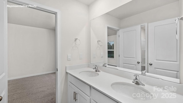 bathroom with baseboards, double vanity, and a sink
