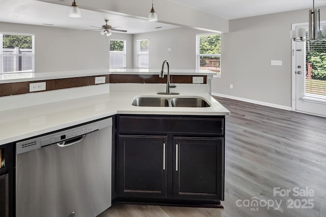 kitchen with a ceiling fan, wood finished floors, dishwasher, a sink, and light countertops
