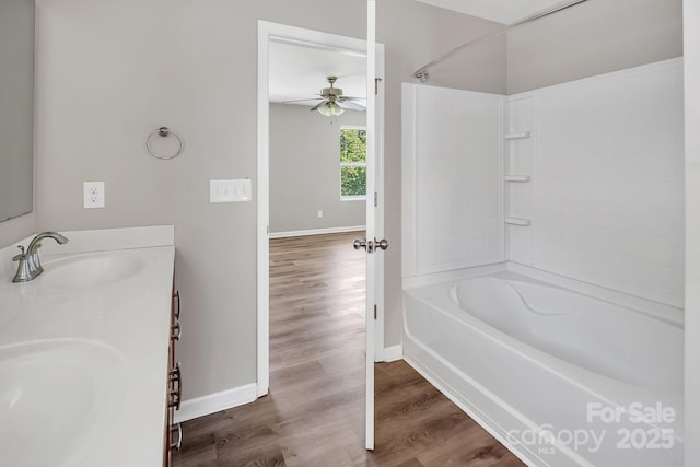 full bath featuring baseboards, a sink, a ceiling fan, and wood finished floors