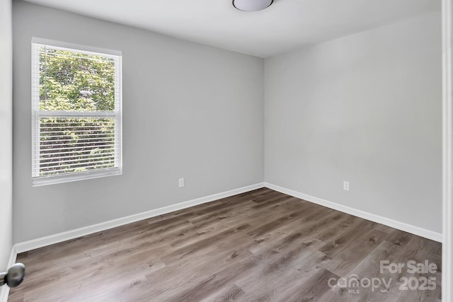 empty room with baseboards and wood finished floors