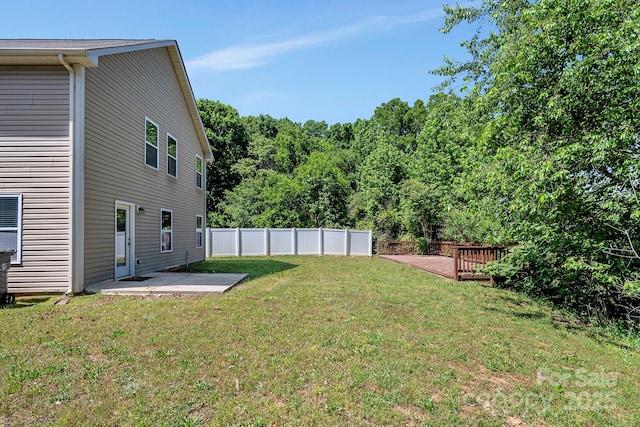 view of yard featuring fence, a patio, and a deck