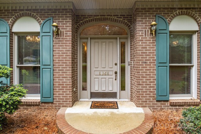 entrance to property featuring brick siding
