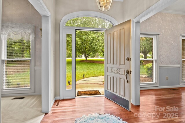 entryway with visible vents, a healthy amount of sunlight, and wood finished floors