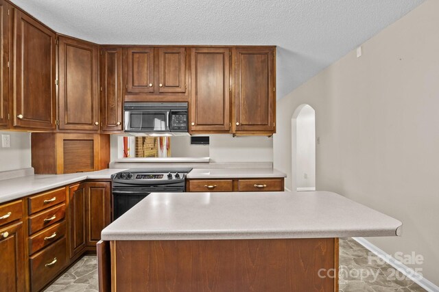 kitchen featuring black microwave, stainless steel electric range oven, a center island, and light countertops