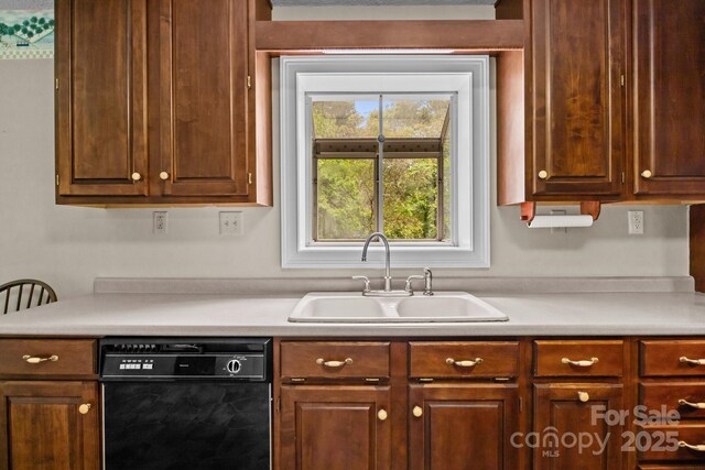 kitchen featuring a sink, black dishwasher, and light countertops