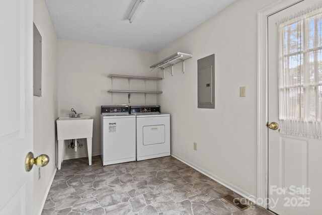 clothes washing area featuring laundry area, visible vents, washing machine and dryer, baseboards, and electric panel