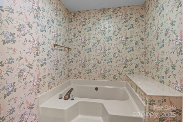 bathroom with a bath and wallpapered walls