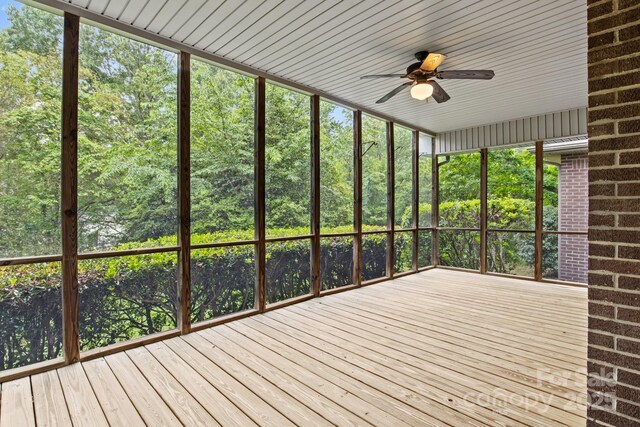 unfurnished sunroom with ceiling fan