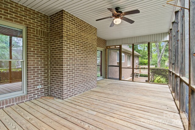 unfurnished sunroom with a ceiling fan