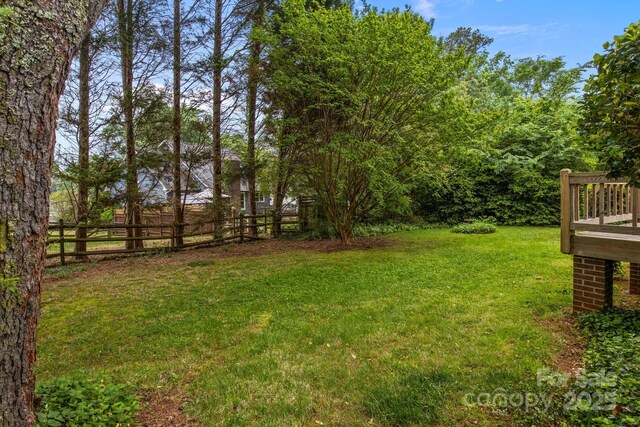 view of yard featuring fence and a wooden deck