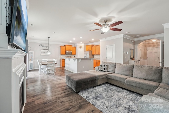living room with arched walkways, ceiling fan, and crown molding