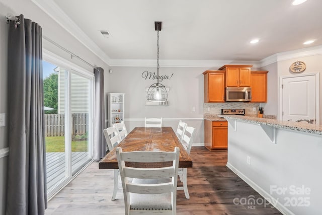 dining space featuring crown molding, recessed lighting, dark wood-style flooring, and visible vents