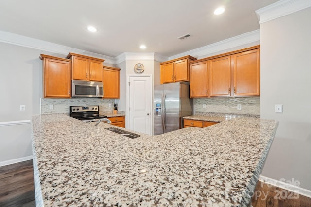 kitchen with stainless steel appliances, visible vents, a peninsula, baseboards, and ornamental molding