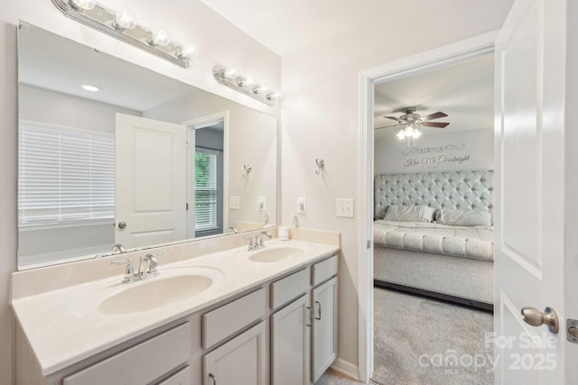 ensuite bathroom with double vanity, ceiling fan, connected bathroom, and a sink