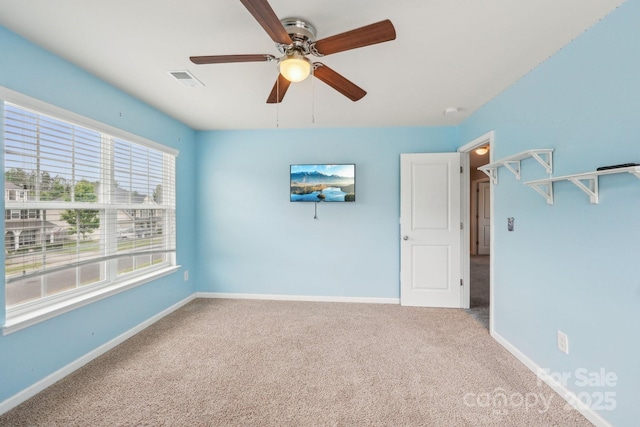 empty room featuring ceiling fan, carpet floors, and baseboards