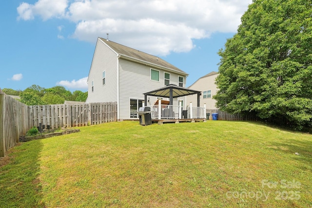 back of house featuring a yard, a deck, a gazebo, and a fenced backyard