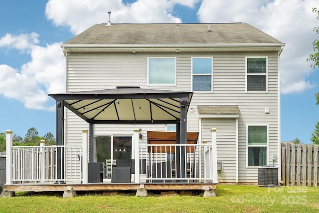 rear view of house featuring a yard, cooling unit, a deck, a gazebo, and fence