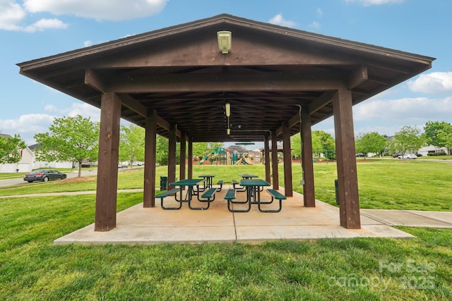 view of property's community with playground community, a yard, and a patio