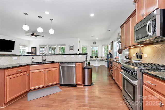 kitchen with appliances with stainless steel finishes, decorative backsplash, recessed lighting, and open floor plan