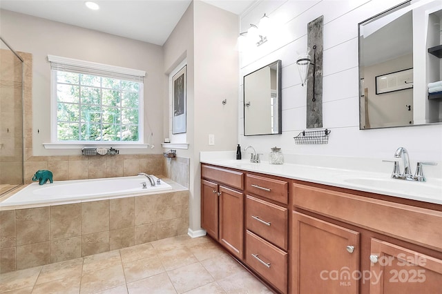bathroom with double vanity, a sink, a bath, and tile patterned floors