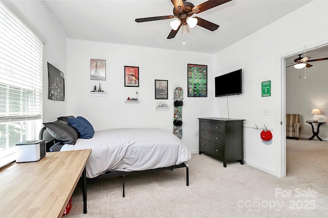 bedroom featuring baseboards, light carpet, and ceiling fan