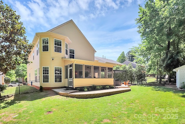 rear view of property with a fenced backyard, a yard, and a sunroom