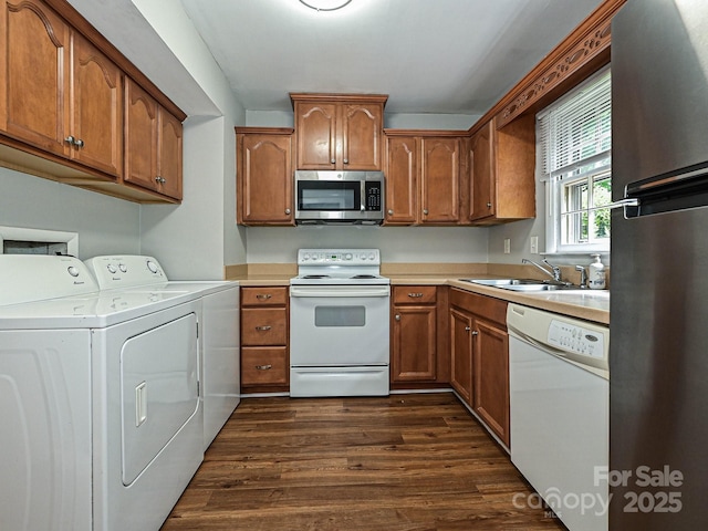 kitchen with a sink, light countertops, separate washer and dryer, stainless steel appliances, and dark wood-style floors