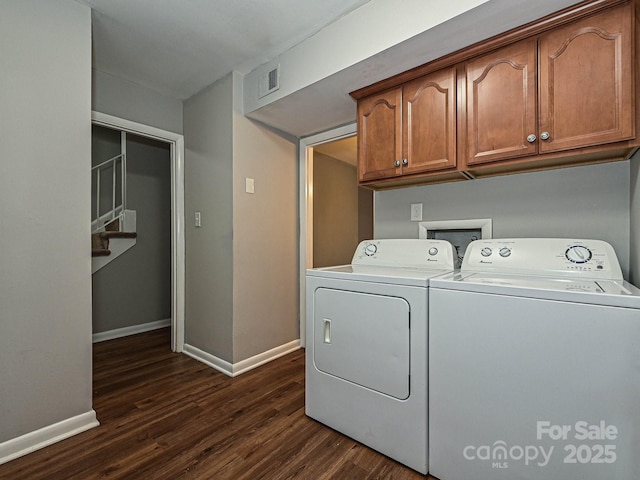 clothes washing area featuring baseboards, cabinet space, washer and dryer, and dark wood-style floors