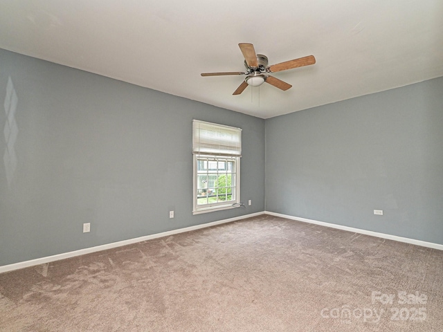 spare room with carpet flooring, baseboards, and ceiling fan