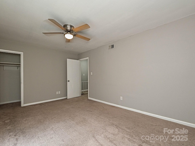unfurnished bedroom with baseboards, ceiling fan, carpet, and visible vents