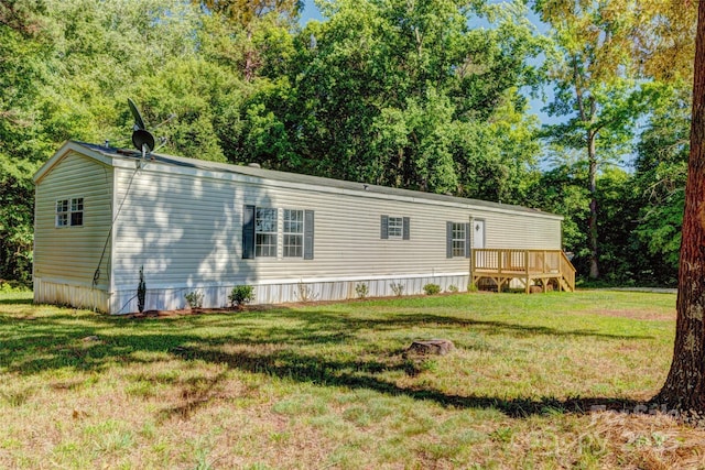 rear view of property with a deck and a yard